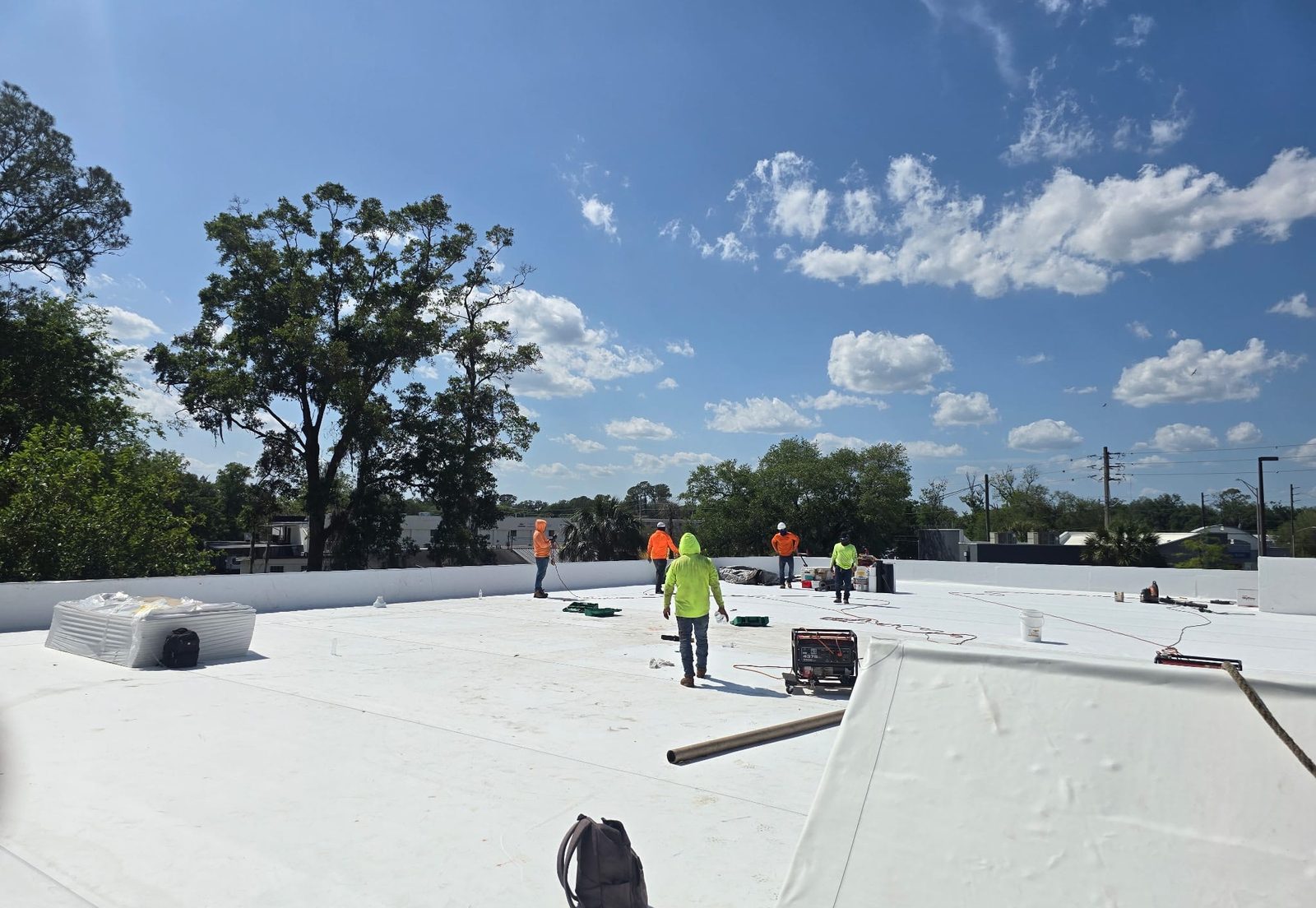 KLO Roofing commercial crew installing a single-ply membrane roof on a Florida commercial building