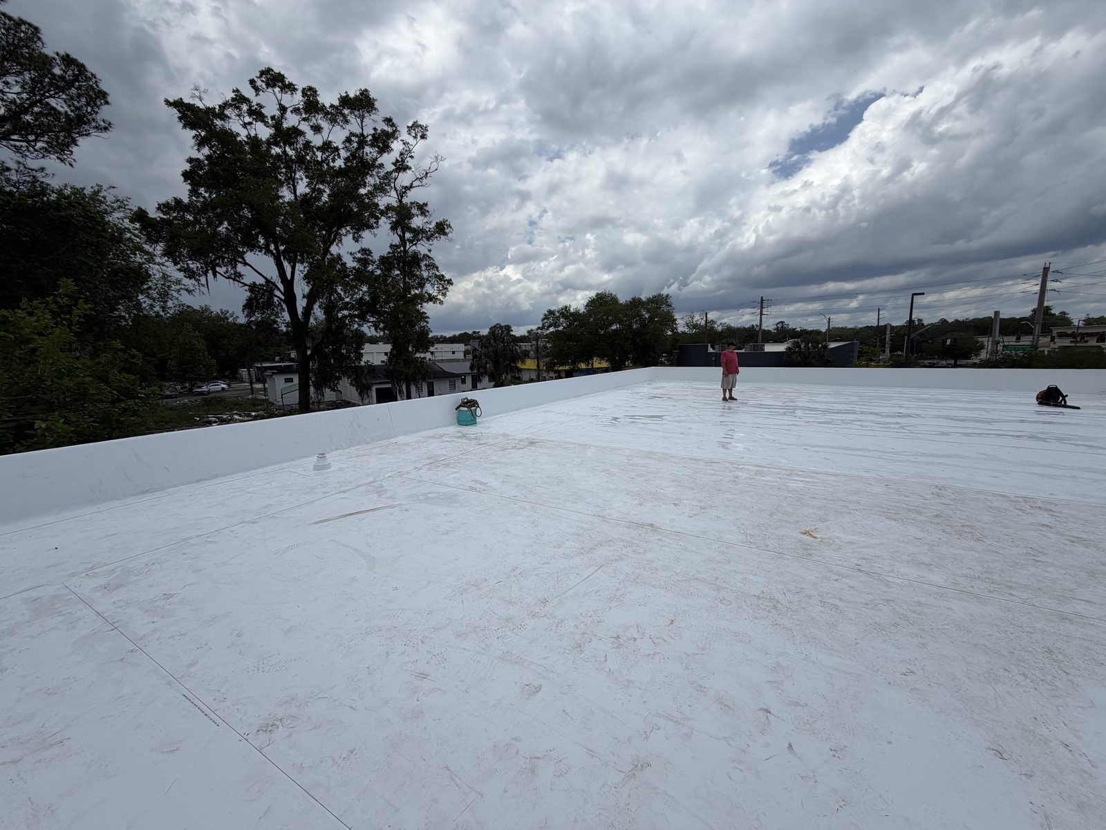 Commercial flat roof single-ply membrane installation in progress with crew